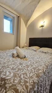 een slaapkamer met een bed met een dekbed en een raam bij La Petit Ourse - Wifi - Terrasse - Vulcania in Saint-Ours