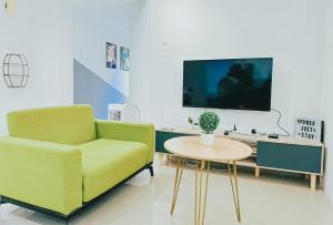 sala de estar con sofá verde y mesa en Modern Suite [12pax] @Farenheit 88 en Kuala Lumpur