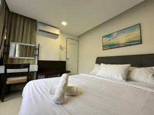 Un dormitorio con una cama blanca con toallas. en Modern Suite [12pax] @Farenheit 88 en Kuala Lumpur