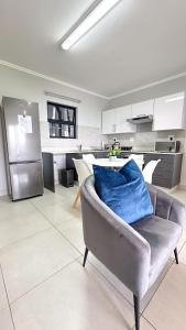 Una sala de estar con un sofá y una cocina. en Umhlanga Cosy Apartment, en Durban