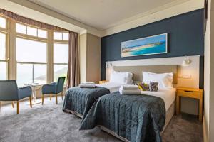 um quarto de hotel com duas camas e uma mesa em The St Ives Bay Hotel em St. Ives