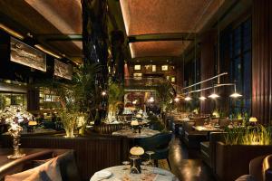 a restaurant with tables and chairs and plants at Double - Six, Luxury Hotel - Seminyak in Seminyak