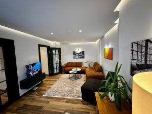sala de estar con sofá y TV en Stylish Downtown Apartment en Pristina