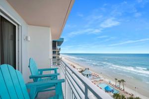 a balcony with two blue chairs and the beach at Luxury 10th Floor 2 BR Condo Direct Oceanfront Wyndham Ocean Walk Resort Daytona Beach | 1027 in Daytona Beach