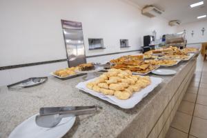 een buffet met borden eten op een aanrecht bij VILLAS DIROMA RESIDENCE - BVTUR in Caldas Novas