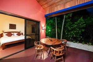 Boutique Hotel Luna Azul في Ostional: غرفة مع طاولة وكراسي وسرير