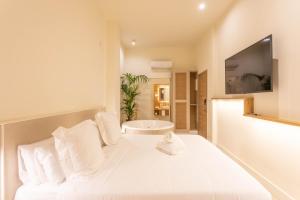 a bedroom with a white bed with a tv on a wall at Reina Victoria Velázquez in Alicante
