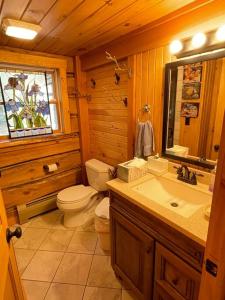 een houten badkamer met een toilet en een wastafel bij Spectacular Seven Keys Camp on Pristine Loon Lake 