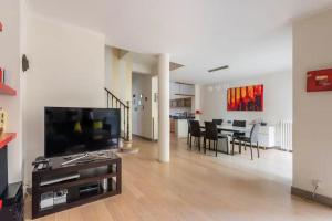 a living room with a television and a dining room at Family house Bordeaux in Bordeaux