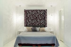 Schlafzimmer mit einem Bett mit einem schwarzen und weißen Kopfteil in der Unterkunft Santa Cruz Apartments in Málaga