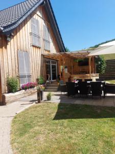 eine Terrasse mit einem Tisch und Stühlen vor einem Haus in der Unterkunft Gemütliches Haus mit Zuber, naturnah! in Weißenborn