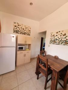 cocina con mesa de madera y nevera blanca en Mini Apartamento Giada, en Nicoya