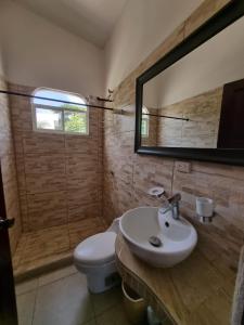 a bathroom with a toilet and a sink and a mirror at Mini Apartamento Giada in Nicoya