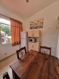 a kitchen with a wooden table and a refrigerator at Mini Apartamento Giada in Nicoya