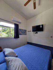 a bedroom with a blue bed and a tv at Mini Apartamento Giada in Nicoya