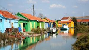 een groep kleurrijke huizen naast een rivier bij Agréable maison ensoleillée avec jardin arboré in Le Château-dʼOléron