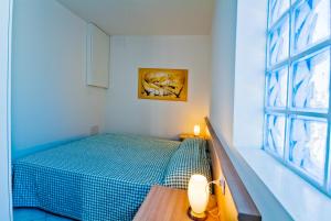 a small bedroom with a green bed and a window at Residence Al Mare - Monolocale con Terrazza - Agenzia Cocal in Caorle