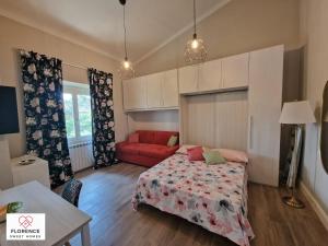 een slaapkamer met een bed en een rode bank bij Lella Apartment with free parking in Florence