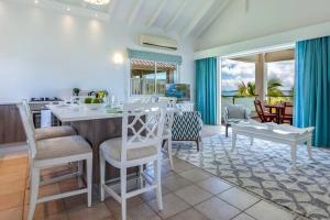 a kitchen and living room with a table and chairs at Seafront sunset & beach access in Saint Martin