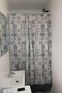 a bathroom with a shower curtain and a sink at Studio indépendant proche Paris in Chennevières-sur-Marne +9 photos