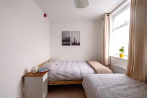a bedroom with two beds and a window at Guildford Town Centre with Parking in Guildford