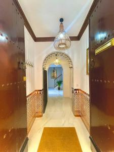 un corridoio con arco e lampadario pendente di House -Rooftop&Jacuzzi -StayInSeville a Siviglia Altre 36 foto