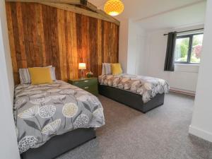 a bedroom with two beds and a window at Windy Willows in Okehampton