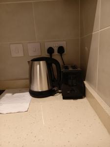 a tea kettle and a toaster on a kitchen counter at Just Nice Stays @ The Gardens in Accra