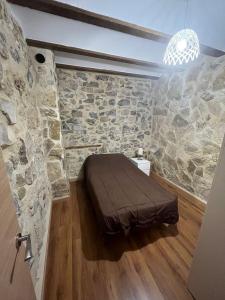 um quarto com uma cama numa parede de pedra em Apartamento Rural Piedra em Jérica