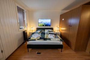 1 dormitorio con 1 cama y TV en la pared en Erza Uno - Cervinia Ski in Ski out Apartment, en Breuil-Cervinia