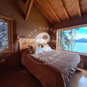a bedroom with a bed and a large window at Eco Cabañas Fardos del Bosque in San Carlos de Bariloche