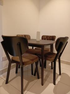 una mesa de madera y sillas en una habitación en Just Nice Stays @ The Gardens, en Accra