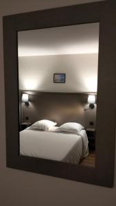 モントルイユにあるHÔTEL ROYAL MONTREUILの白いベッド付きのベッドルームを反映する鏡