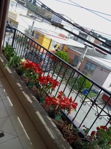 un balcón con un ramo de flores rojas en Habitación cómoda, en Villa Nueva