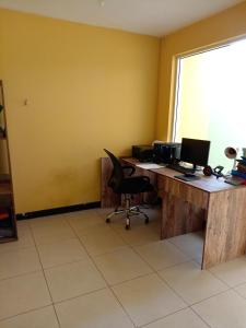 an office with a desk with two computers on it at Habitación cómoda in Villa Nueva