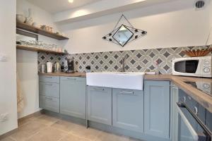 a kitchen with blue cabinets and a microwave at Le Moulin Belle Maison 180m2 et 5 chambres in Valence