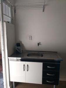 a kitchen with a sink and a counter top at Kitnet espaçosa e bem localizada - Próximo ao lago e centro de eventos in Cascavel