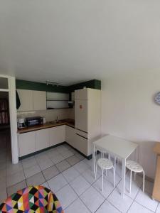 een keuken met een tafel en 2 krukken bij Ap4 Nature Ardennes Economy class apartment in La Calamine