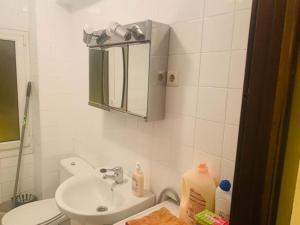 y baño con lavabo, aseo y espejo. en Apartament 3 Bedrooms 80m2 con WIFI Alto Campoo Reinosa Cantabria, en Reinosa