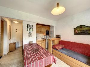 a room with a red couch and a kitchen at Appartement Combloux, 2 pièces, 5 personnes - FR-1-560-61 in Combloux