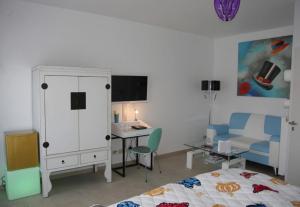a bedroom with a bed and a desk and a cabinet at Gäste-Zimmer am Elberadweg in Damnatz