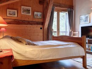 ein Schlafzimmer mit einem Bett in einem Zimmer mit Holzwänden in der Unterkunft Ferme Chalet rénovée 3 étoiles à Cordon - FR-1-560-102 in Cordon + 14 Fotos