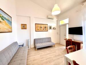 a living room with a couch and a flat screen tv at Villa Poetto Beach by Home and Experience , Cagliari, Poetto in Cagliari