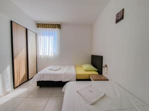 a small bedroom with a bed and a window at Vila Novak in Novalja