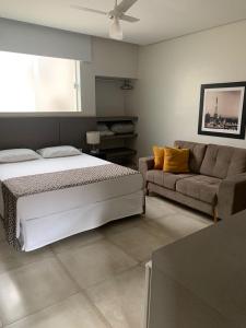 1 dormitorio con 1 cama y 1 sofá en Hotel Ouro Verde en Três Pontas