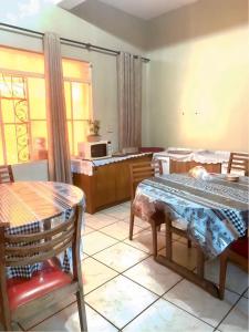 ein Wohnzimmer mit einem Tisch und Stühlen sowie eine Küche in der Unterkunft Hotel Económico in Campo Grande