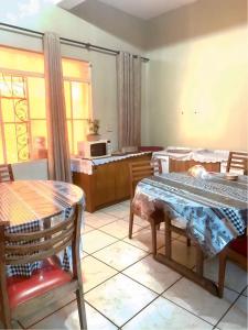a living room with a table and chairs and a kitchen at Hotel Económico in Campo Grande