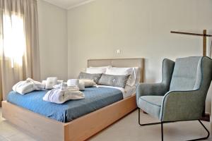 a bedroom with a bed and a blue chair at Serenity Retreat , By IdealStay Experience in Gournes