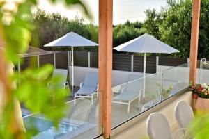 un patio con sombrillas y sillas en el balcón en Serenity Retreat , By IdealStay Experience, en Gournes