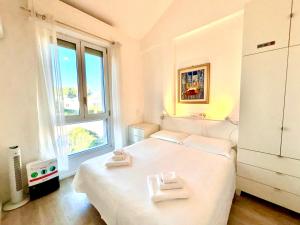 a bedroom with a white bed with two towels on it at Villa Poetto Beach by Home and Experience , Cagliari, Poetto in Cagliari